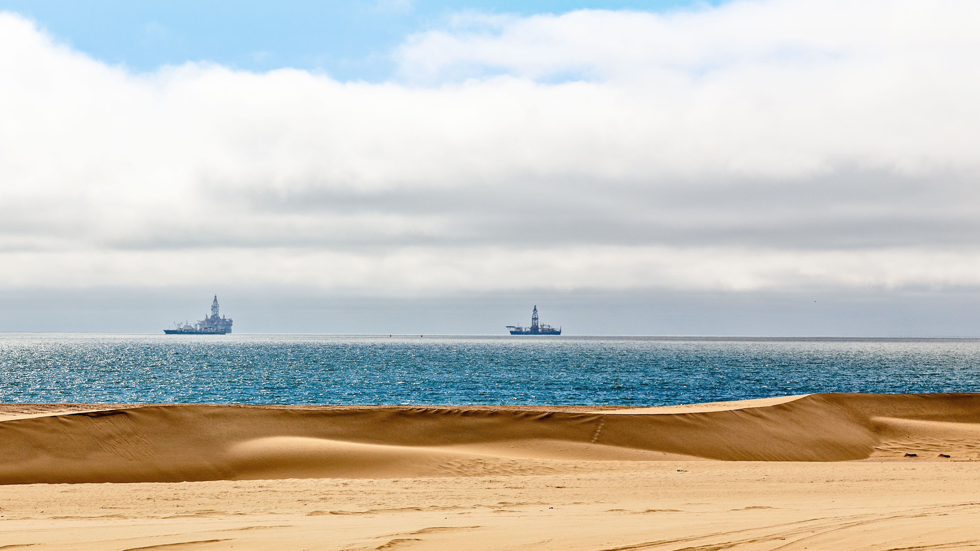 Desert and seaside with offshore oil rigs