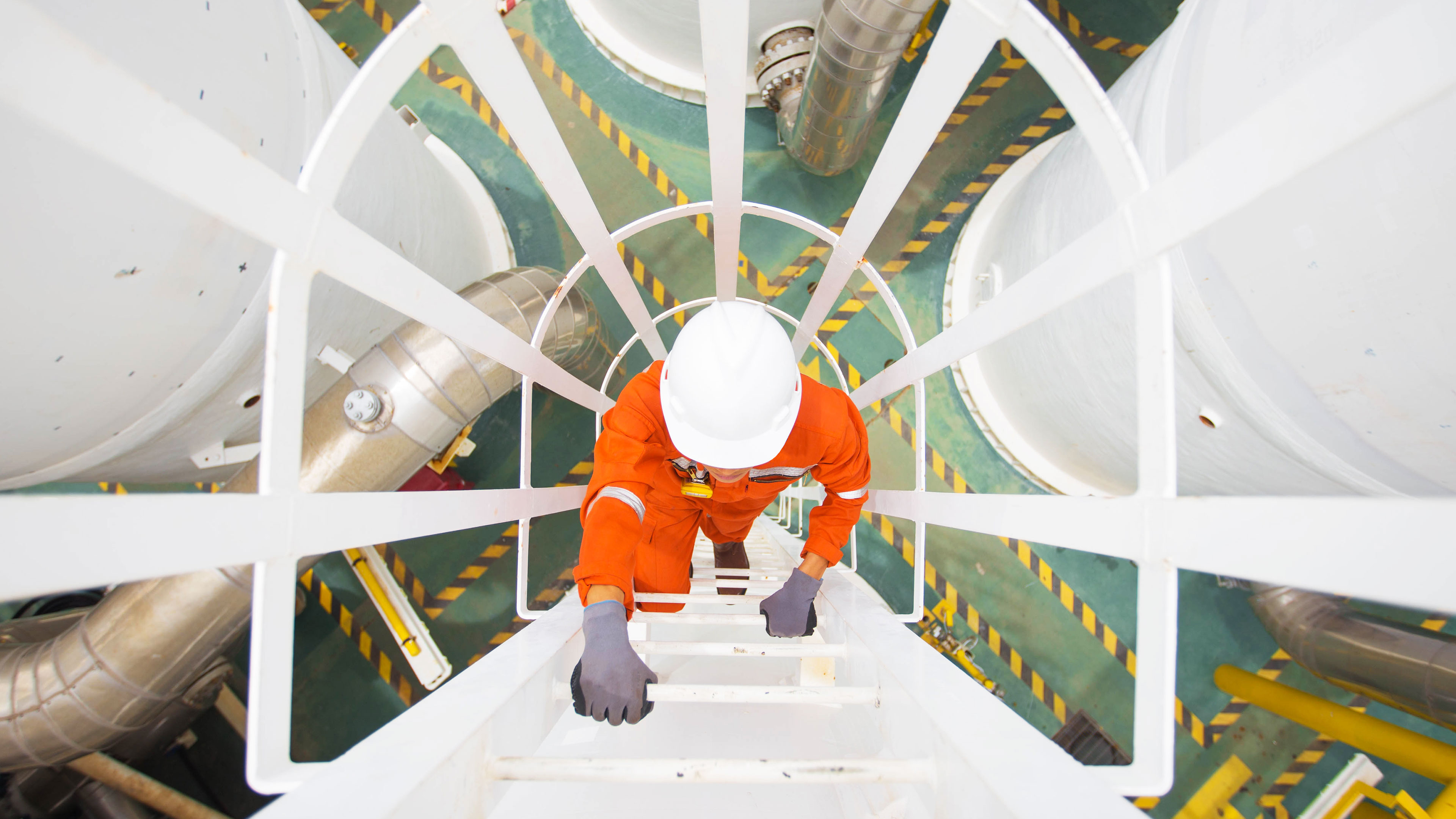 engineer climbing up to the top of a gas dehydration vessel